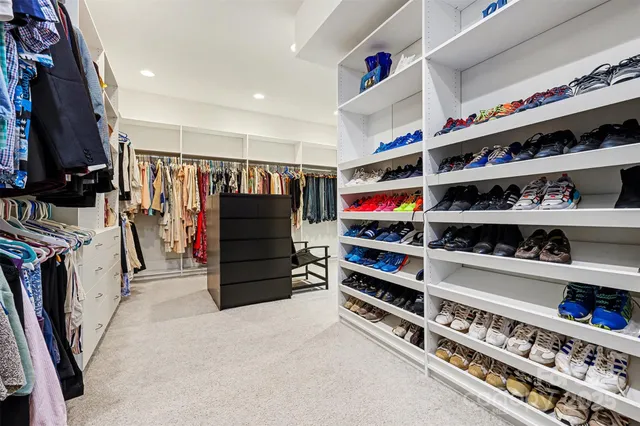 a view of walk in closet with clothes and shoes