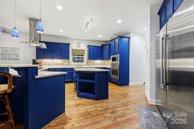 a kitchen with stainless steel appliances granite countertop wooden cabinets a counter top space a sink and cabinets