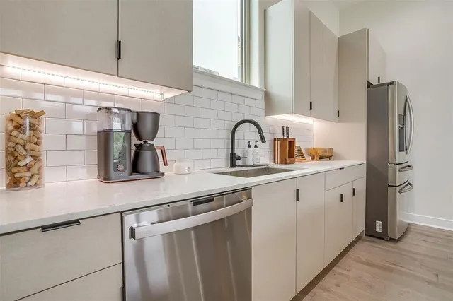 a kitchen with stainless steel appliances a sink and refrigerator