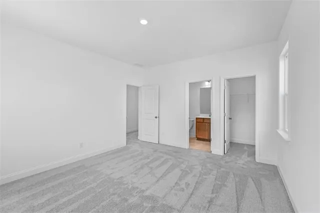 a view of an empty room with wooden floor and closet