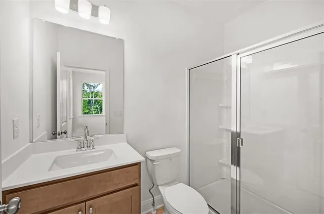 a bathroom with a sink toilet vanity and shower