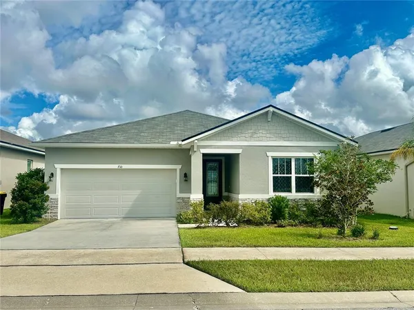 a front view of a house with a yard and potted plants