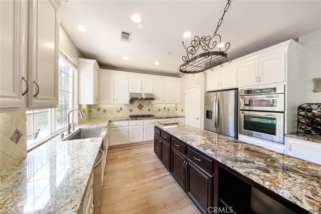 6402 Camino Ventosa San Clemente, CA 92673 - Photo 11 of 67 a large kitchen with stainless steel appliances granite countertop a sink a stove and a wooden cabinets