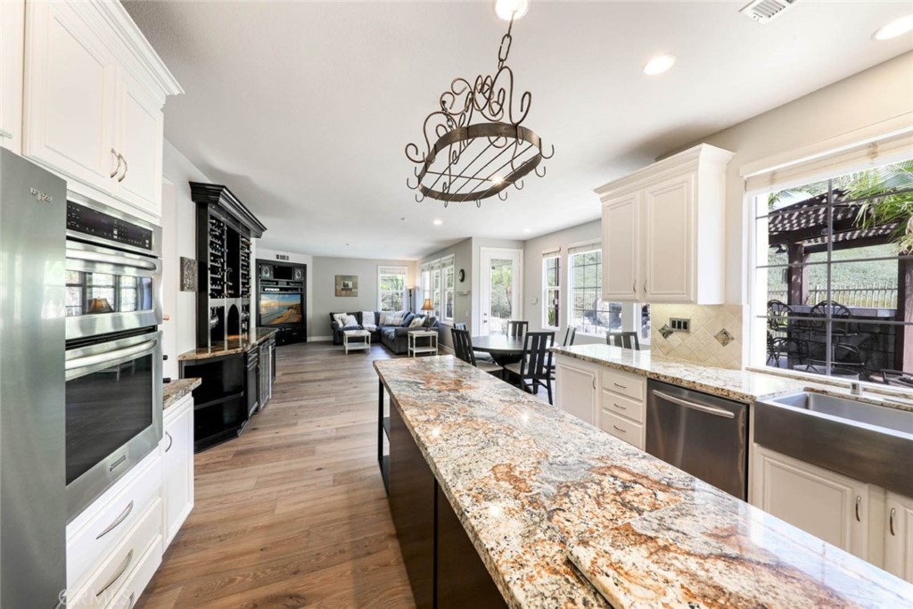 6402 Camino Ventosa San Clemente, CA 92673 - Photo 12 of 67 a large kitchen with kitchen island a large counter space a sink stainless steel appliances and cabinets