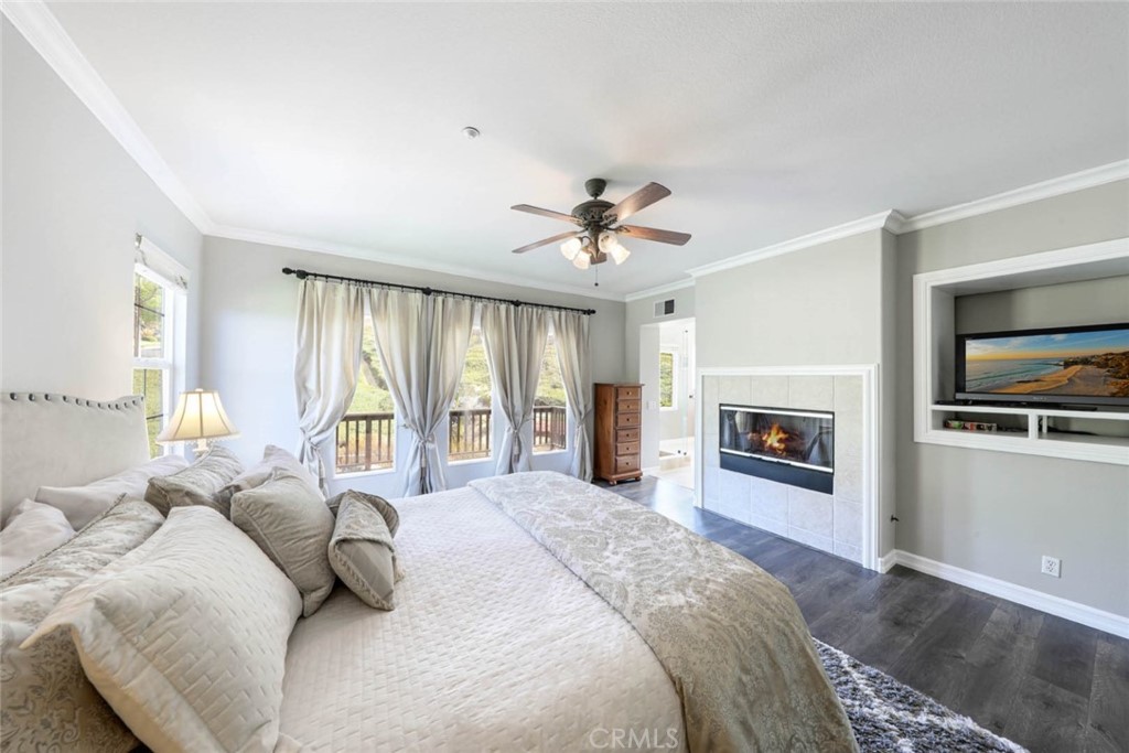 6402 Camino Ventosa San Clemente, CA 92673 - Photo 24 of 67 a spacious bedroom with a bed a fireplace and a chandelier