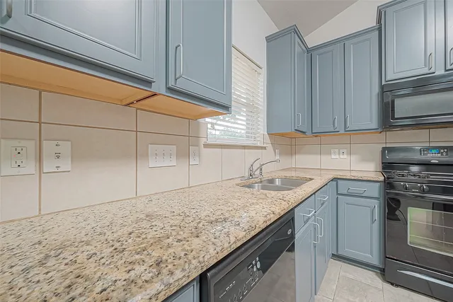a kitchen with granite countertop cabinets stainless steel appliances and sink