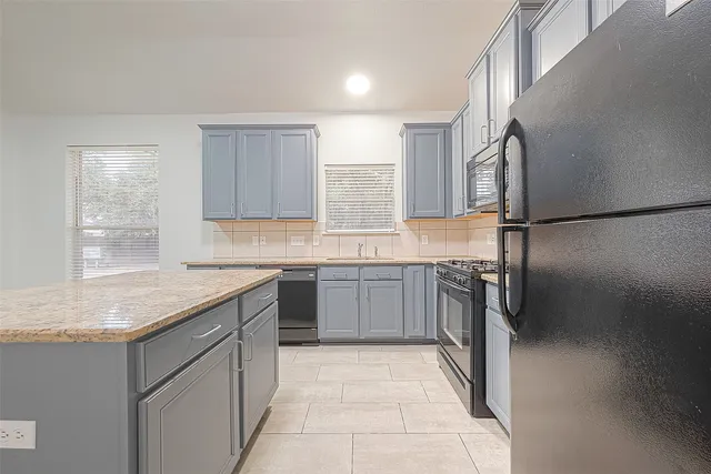 a kitchen with a sink a refrigerator and a stove