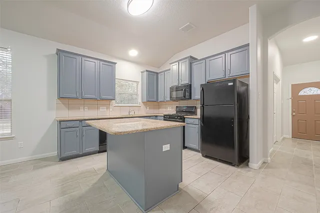a kitchen with a refrigerator sink and cabinets