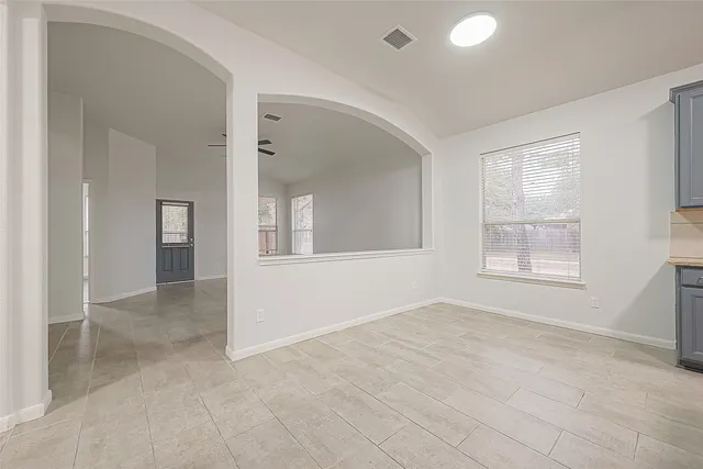 an empty room with windows and cabinet
