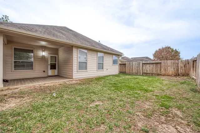 a view of a house with a yard and wooden fence