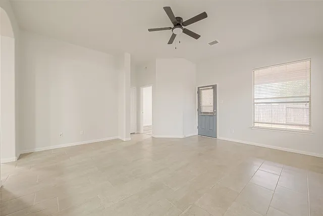 an empty room with a window and a fan