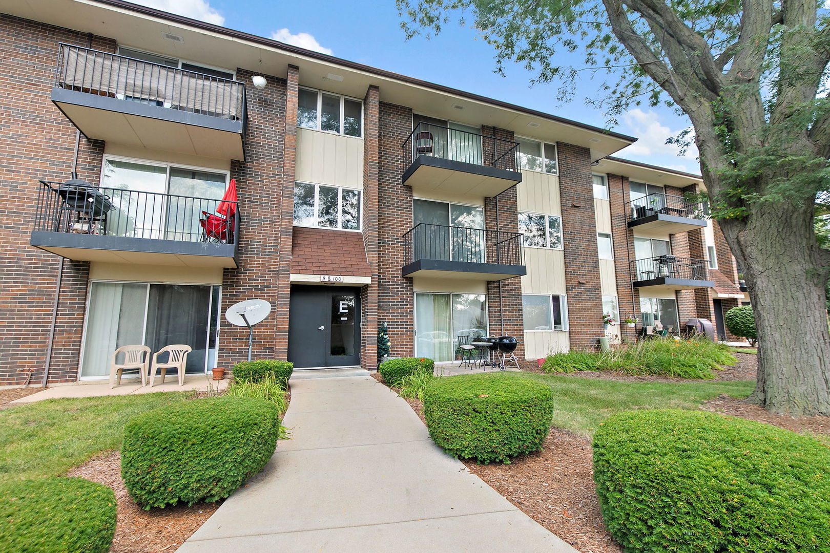 5s100 Pebblewood Lane, Unit E6 Naperville, IL 60563 - Photo 18 of 18 a front view of a brick house with a yard