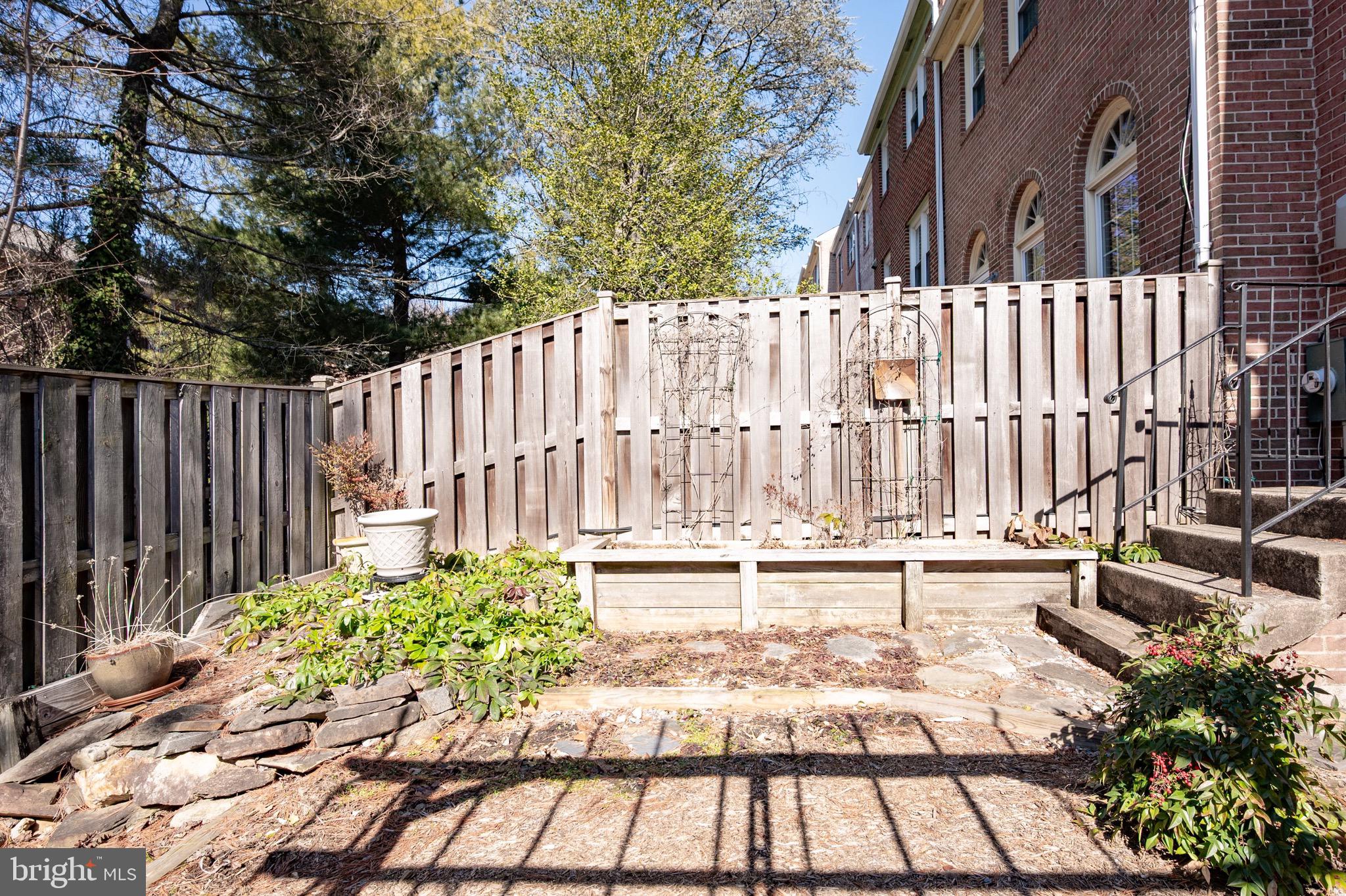 2436 Windbreak Drive Alexandria, VA 22306 - Photo 23 of 36 a view of a backyard with large trees and wooden fence