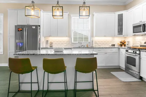 a kitchen with stainless steel appliances granite countertop a stove a sink and a refrigerator