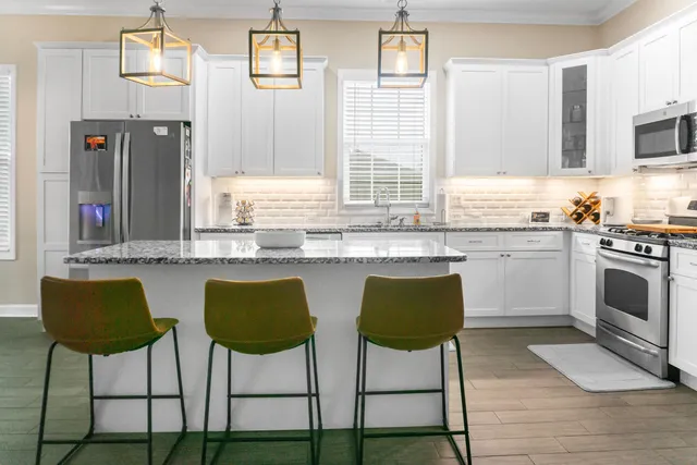 a kitchen with stainless steel appliances granite countertop a stove a sink and a refrigerator