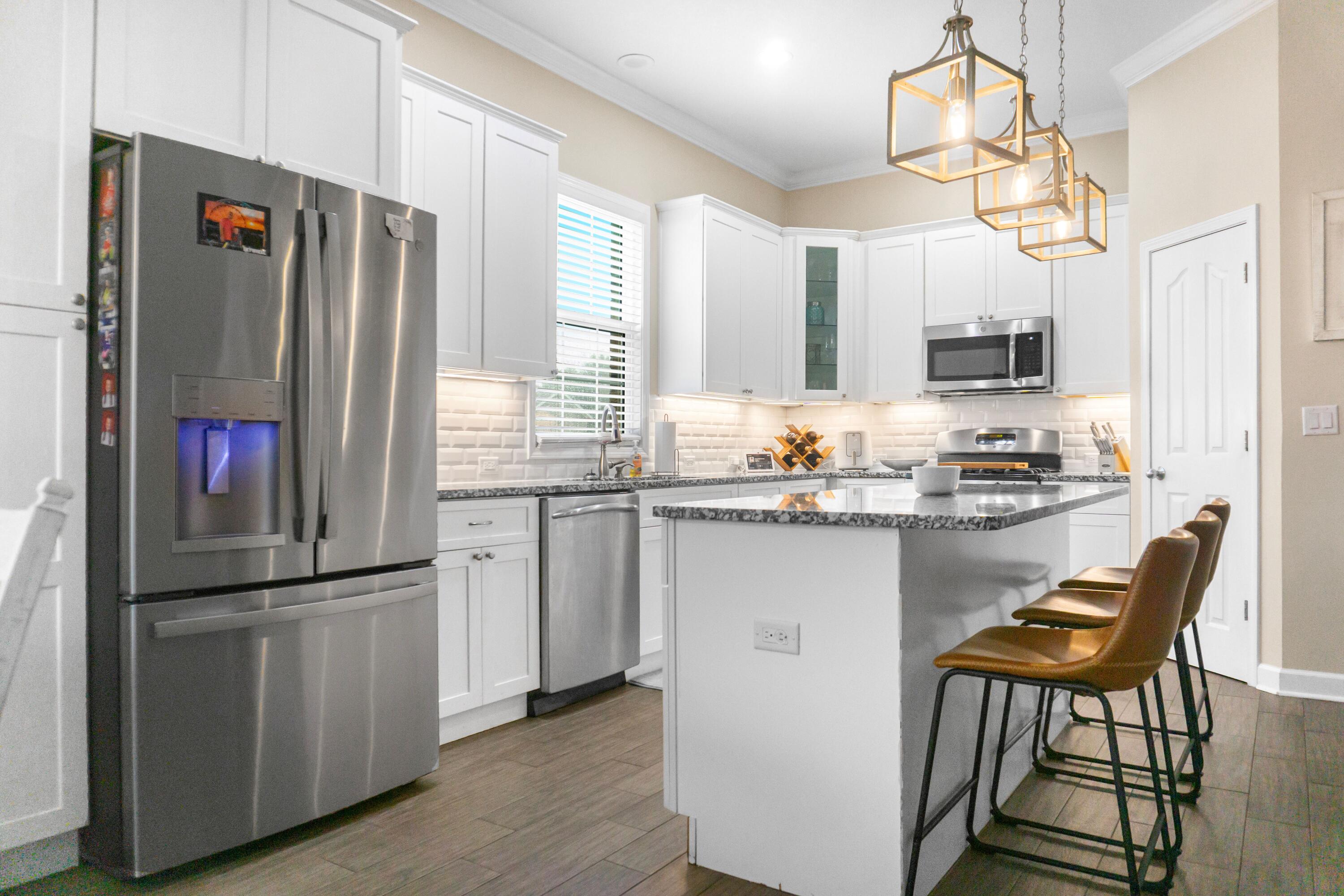 2902 Short Tail Court Panama City, FL 32405 - Photo 14 of 46 a kitchen with stainless steel appliances granite countertop a refrigerator a stove a sink dishwasher and a refrigerator with wooden floor