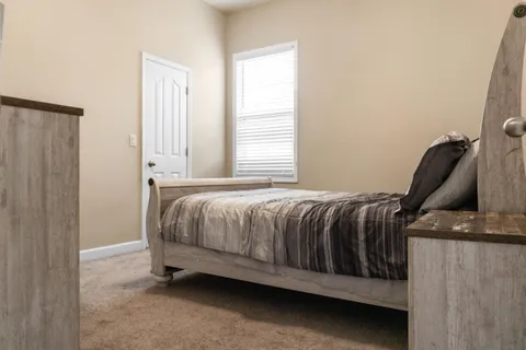 a room with a flat screen tv and a ceiling fan
