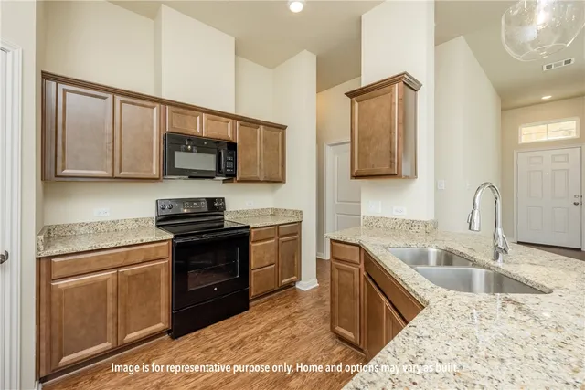a kitchen with stainless steel appliances granite countertop a sink stove and microwave