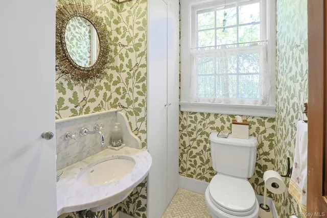 a bathroom with a toilet a sink and a mirror