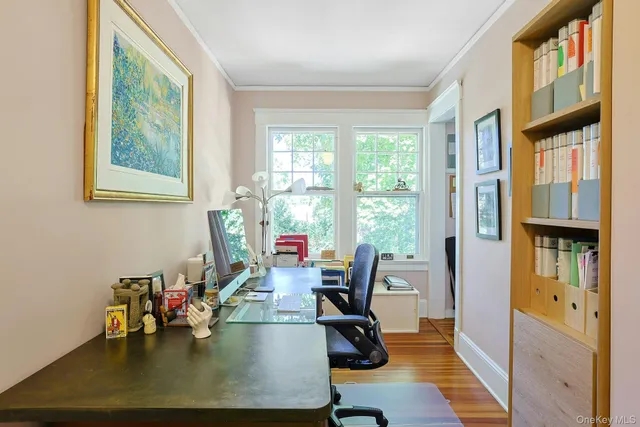 a view of a workspace with furniture and a window