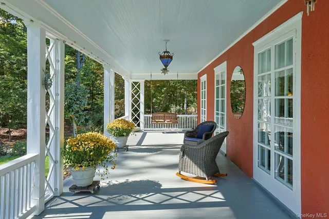 a porch with a bench next to a yard