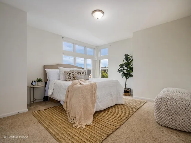a bedroom with a large bed and a potted plant