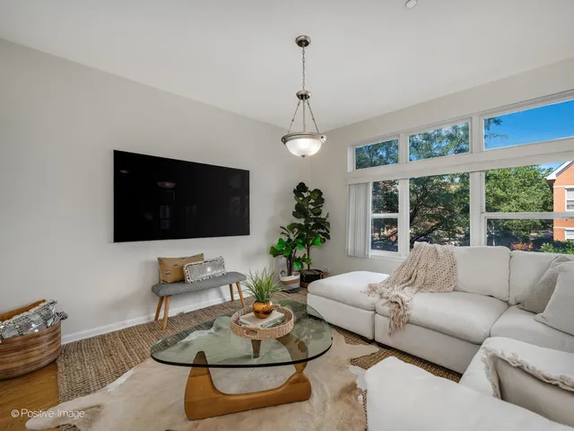a living room with furniture a flat screen tv and a large window