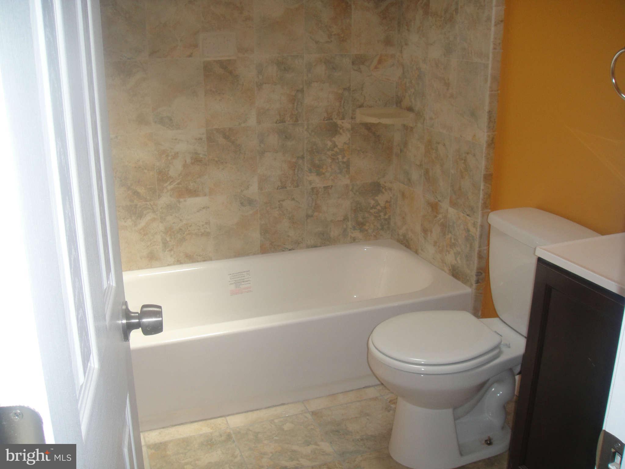 625 Columbia Road Northwest Washington, DC 20001 - Photo 12 of 26 a bathroom with a toilet and a bath tub