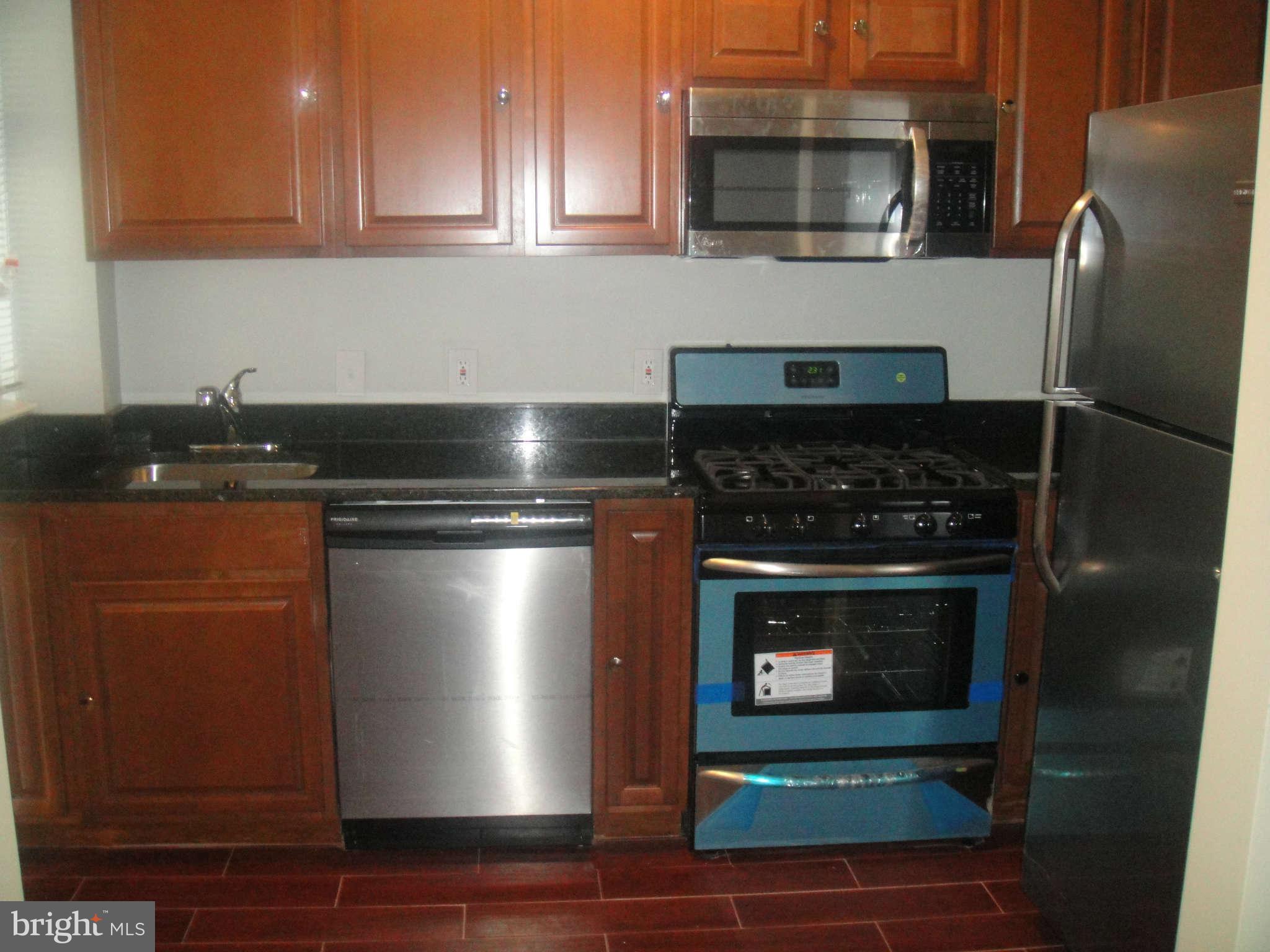 625 Columbia Road Northwest Washington, DC 20001 - Photo 3 of 26 a kitchen with granite countertop a stove and a microwave