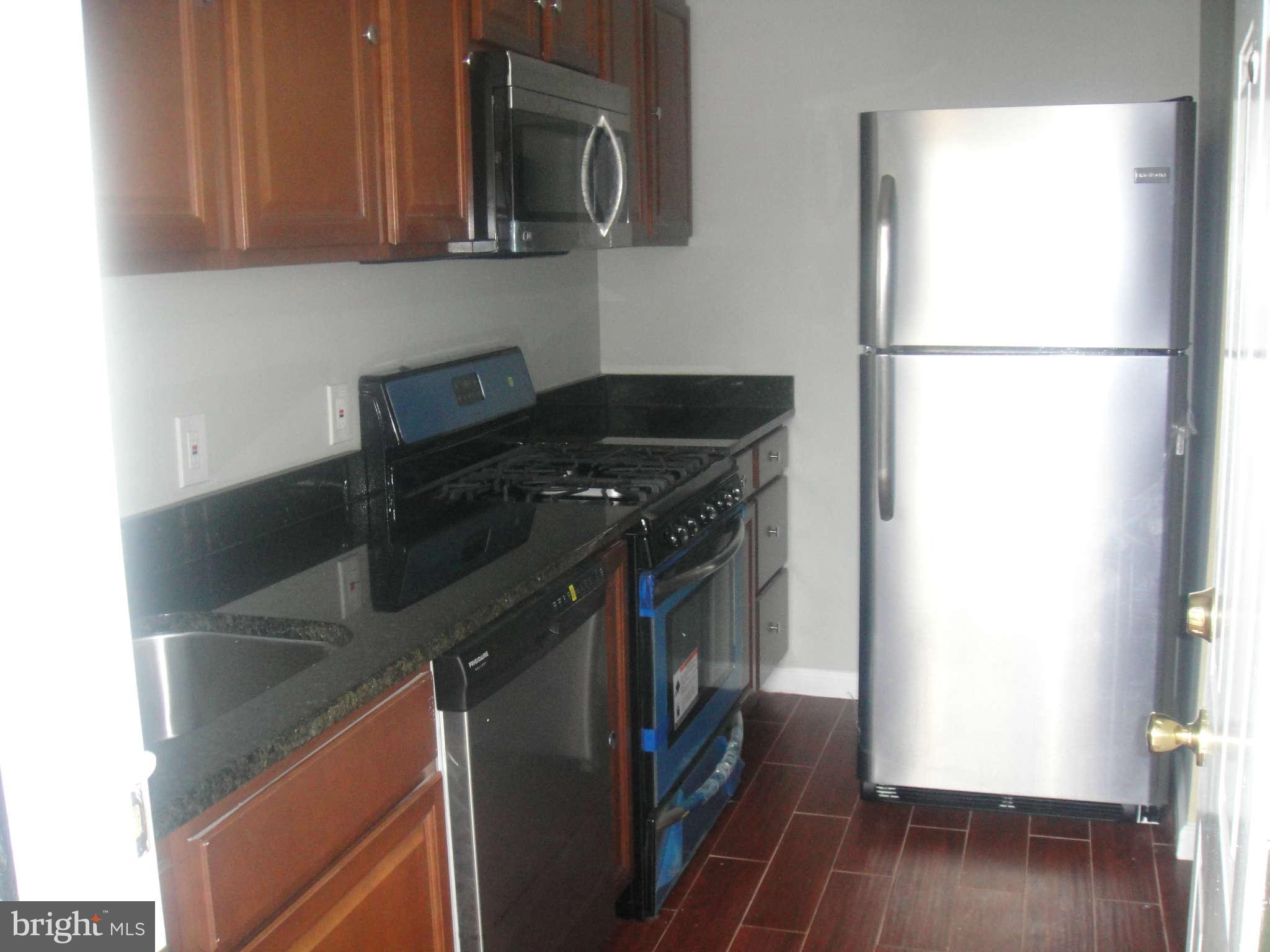 625 Columbia Road Northwest Washington, DC 20001 - Photo 7 of 26 a kitchen with a refrigerator and a stove top oven