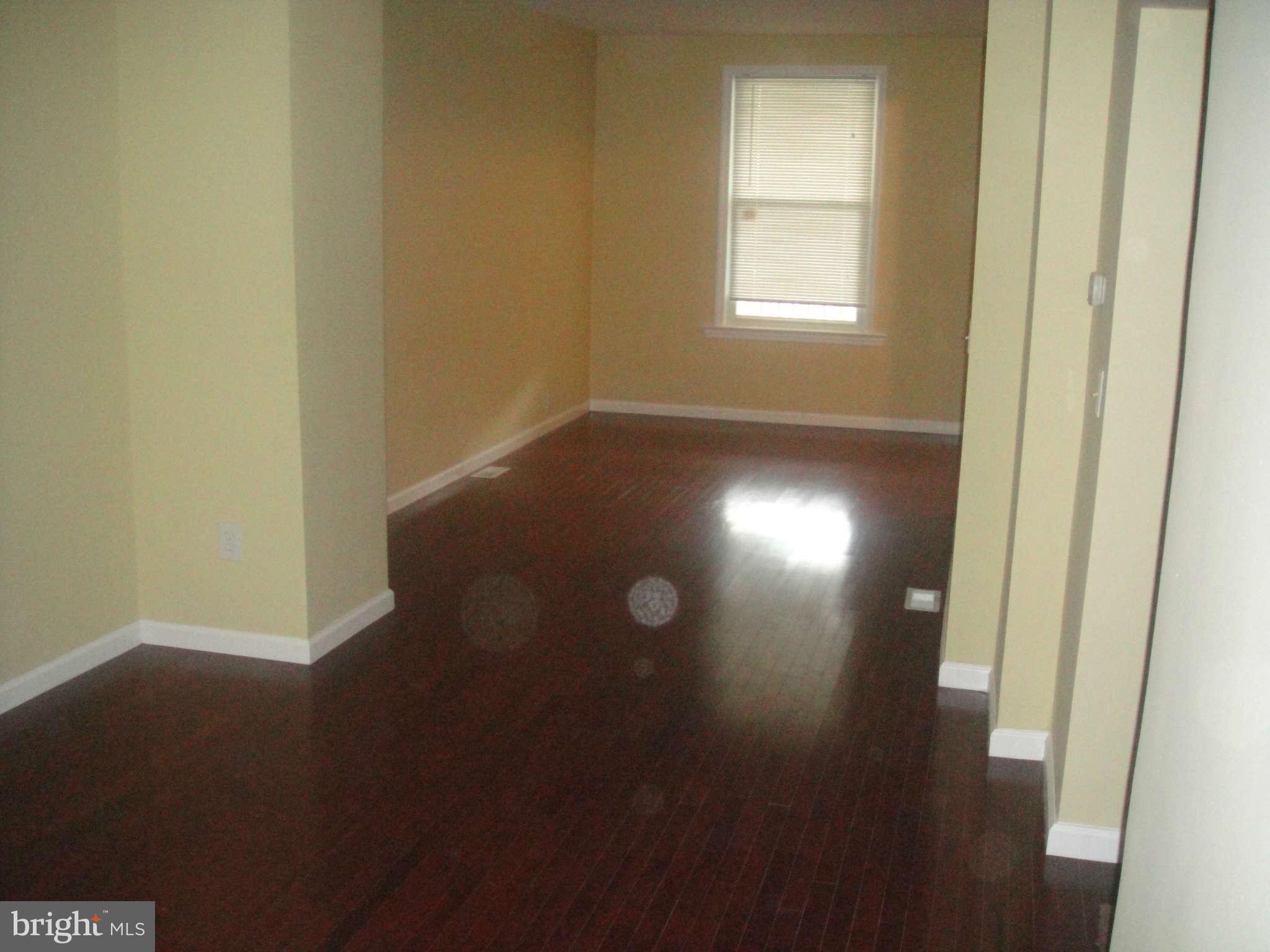 625 Columbia Road Northwest Washington, DC 20001 - Photo 9 of 26 a view of an empty room with wooden floor and a window