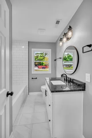 a bathroom with a granite countertop sink a window and a mirror