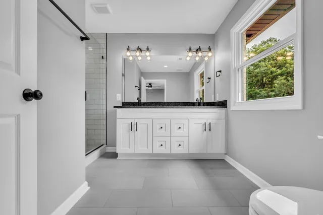 a spacious bathroom with a granite countertop sink and a mirror