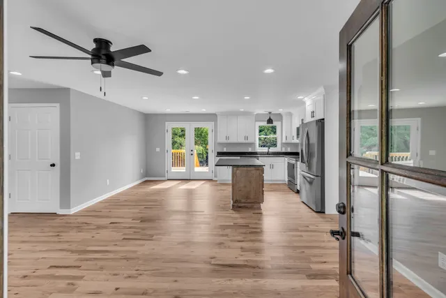 a view of kitchen with kitchen island wooden floor center island and stainless steel appliances