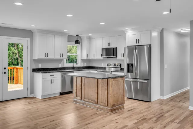 a kitchen with stainless steel appliances granite countertop a refrigerator a sink a stove a microwave and cabinets