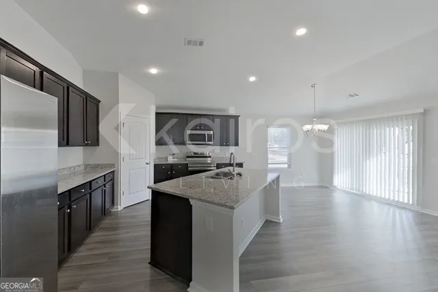a kitchen with stainless steel appliances granite countertop a sink stove and refrigerator