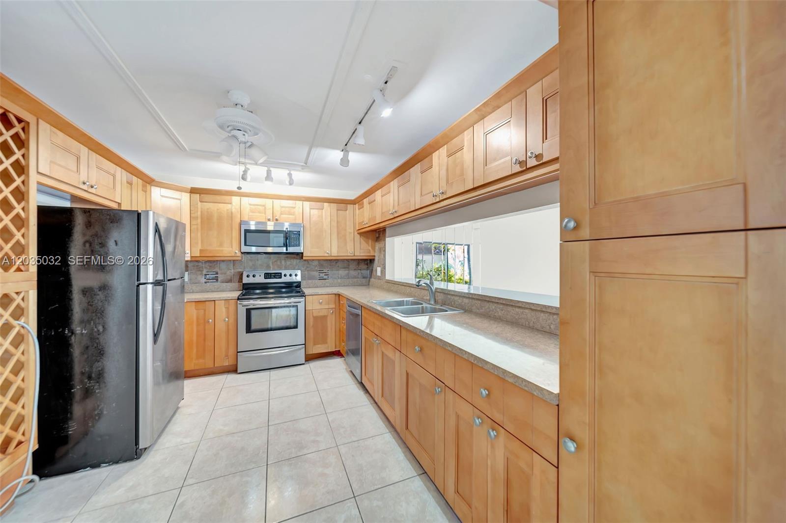 5223 Gate Lake Road, Unit 5223 Tamarac, FL 33319 - Photo 10 of 37 a large kitchen with cabinets and stainless steel appliances