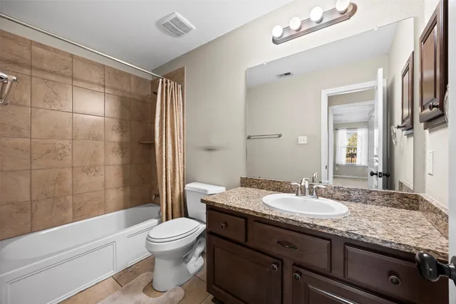 a bathroom with a granite countertop sink toilet a mirror and shower