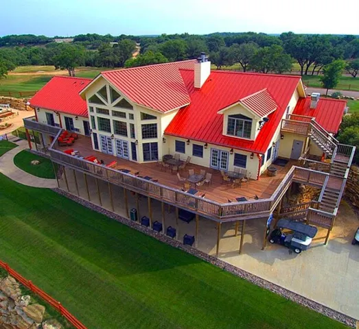 an aerial view of a house with pool and deck