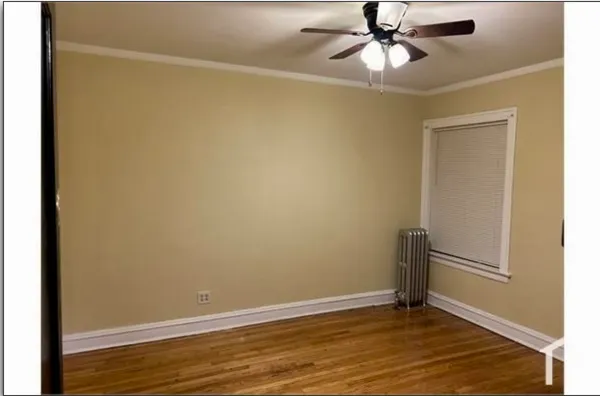 an empty room with wooden floor closet and windows