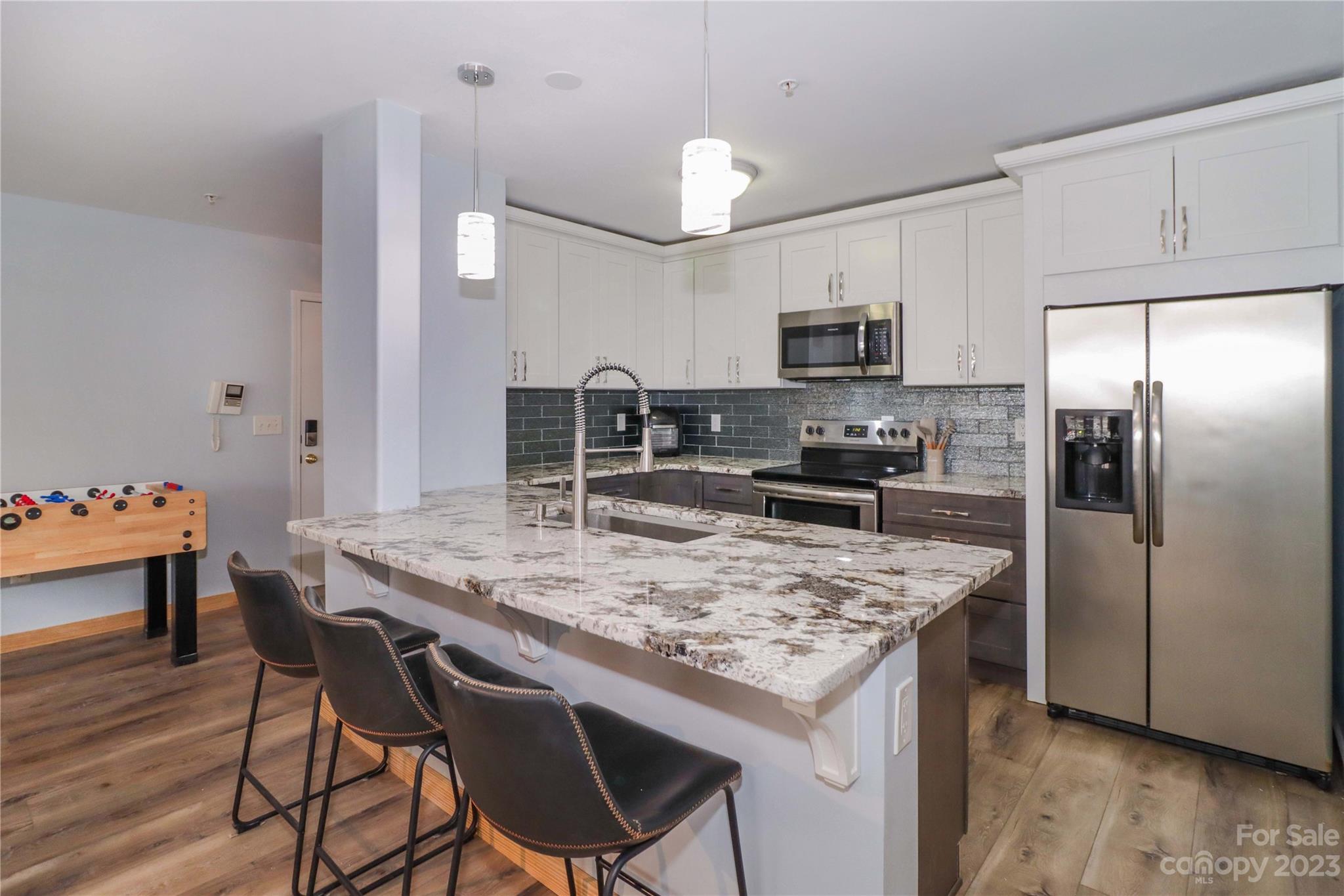 160 James Road, Unit 1D High Point, NC 27265 - Photo 12 of 33 a kitchen with stainless steel appliances granite countertop a kitchen island a stove a table and a refrigerator
