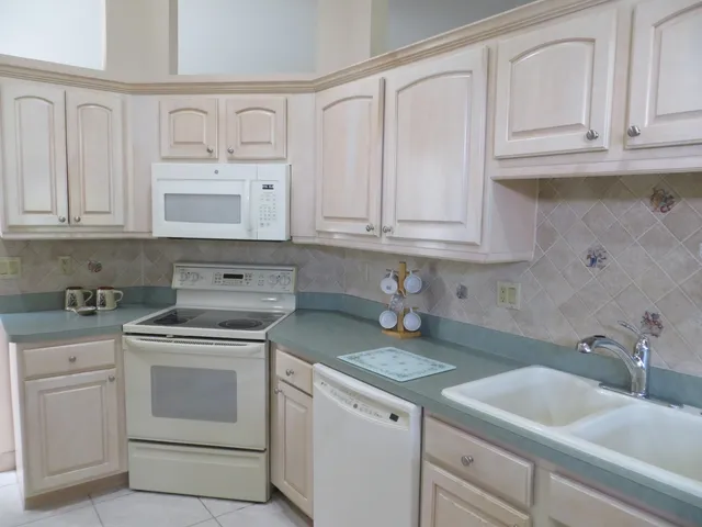 a kitchen with granite countertop white cabinets and a sink