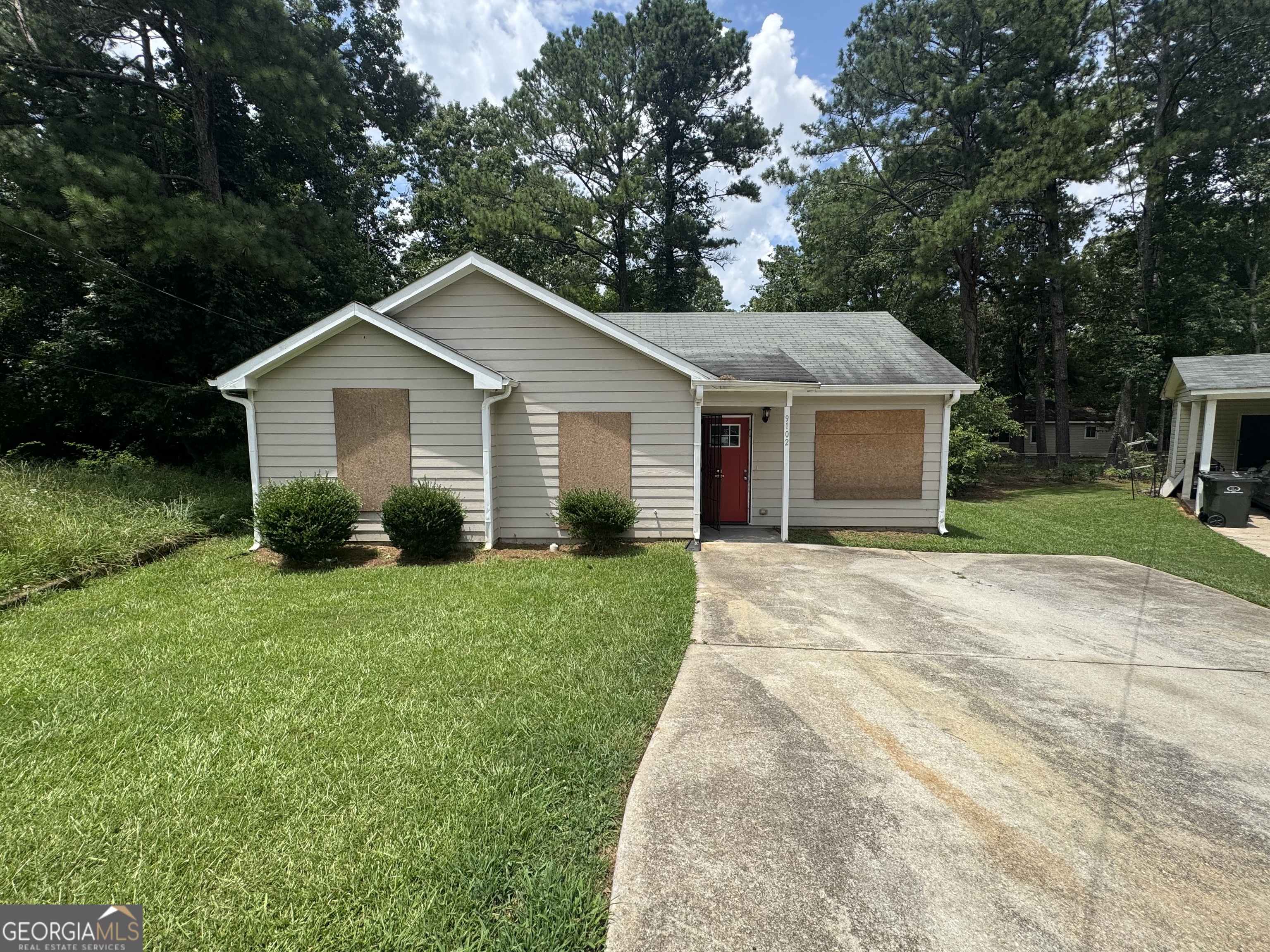 9102 Morris Drive Southwest Covington, GA 30014 - Photo 2 of 3 a view of a yard in front of a house with large windows