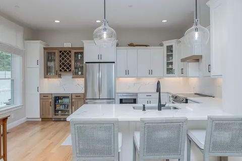 a kitchen with kitchen island a stove a sink and a refrigerator