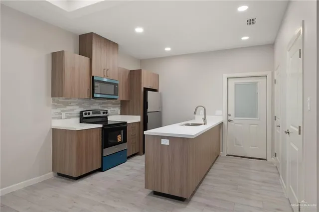 a kitchen with stainless steel appliances a sink stove and refrigerator