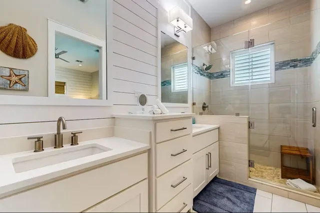 a bathroom with a double vanity sink mirror and bathtub