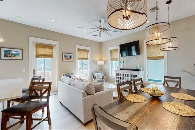 a living room with kitchen island furniture a chandelier and a dining table