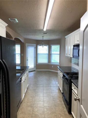 a kitchen with granite countertop a sink and a stove