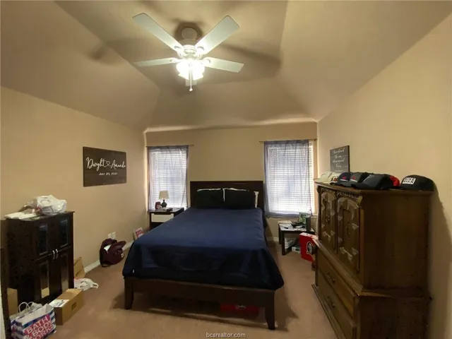 a bedroom with a bed and a ceiling fan