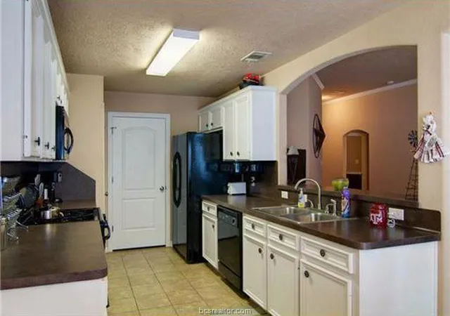 a kitchen with granite countertop a stove and a sink